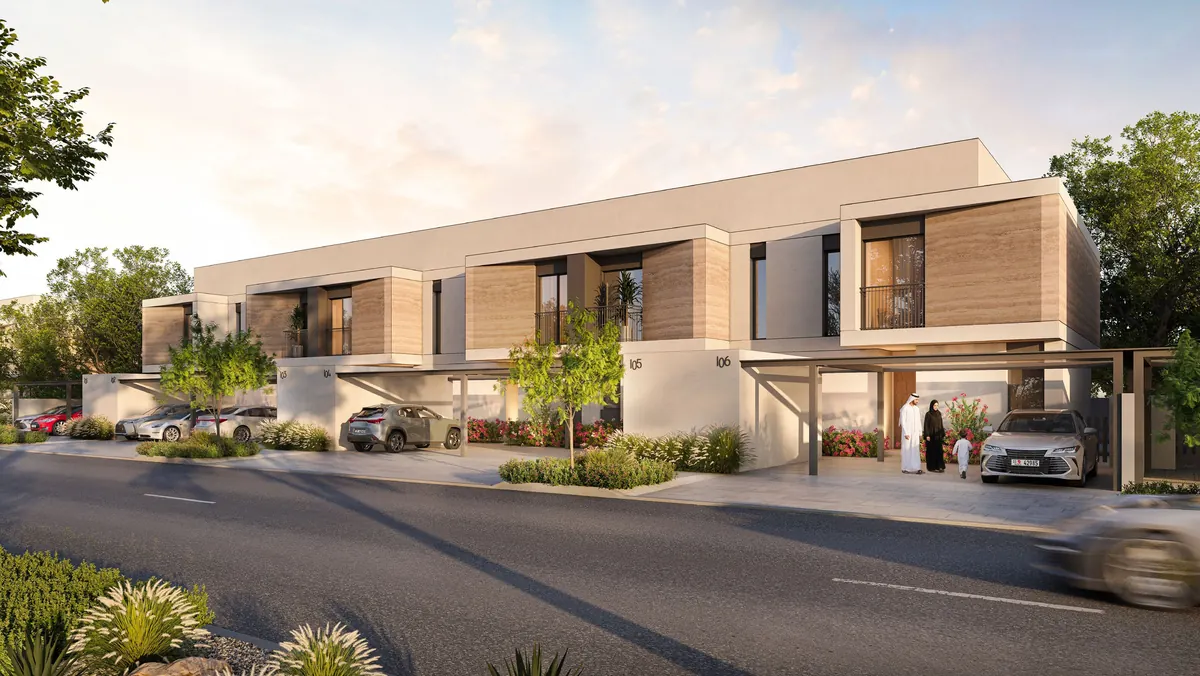 A row of Al Ghadeer Parks townhouses with timber-clad upper floors and shaded carports