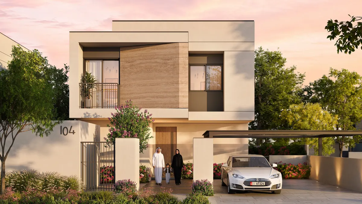 A 4-bedroom Al Ghadeer Parks villa with a timber-clad upper volume and a family at the front gate